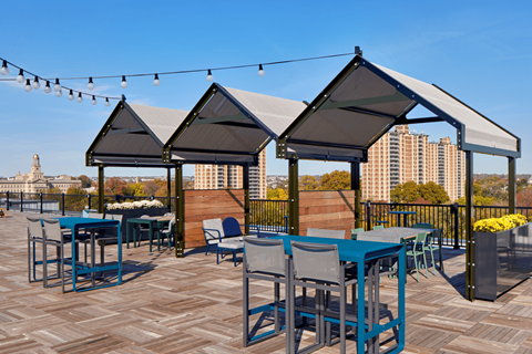 a roof top patio with tables and chairs and gazebos