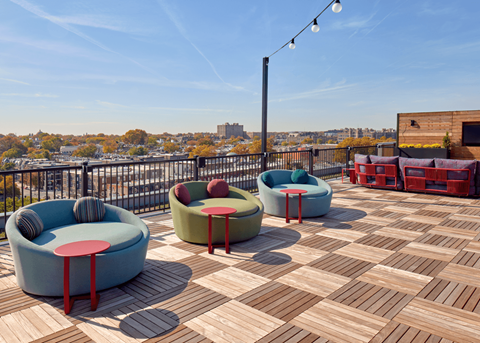 a roof deck with furniture and a view of the city