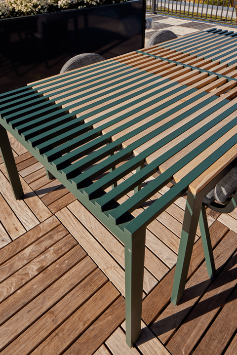 a green picnic table on a wooden deck