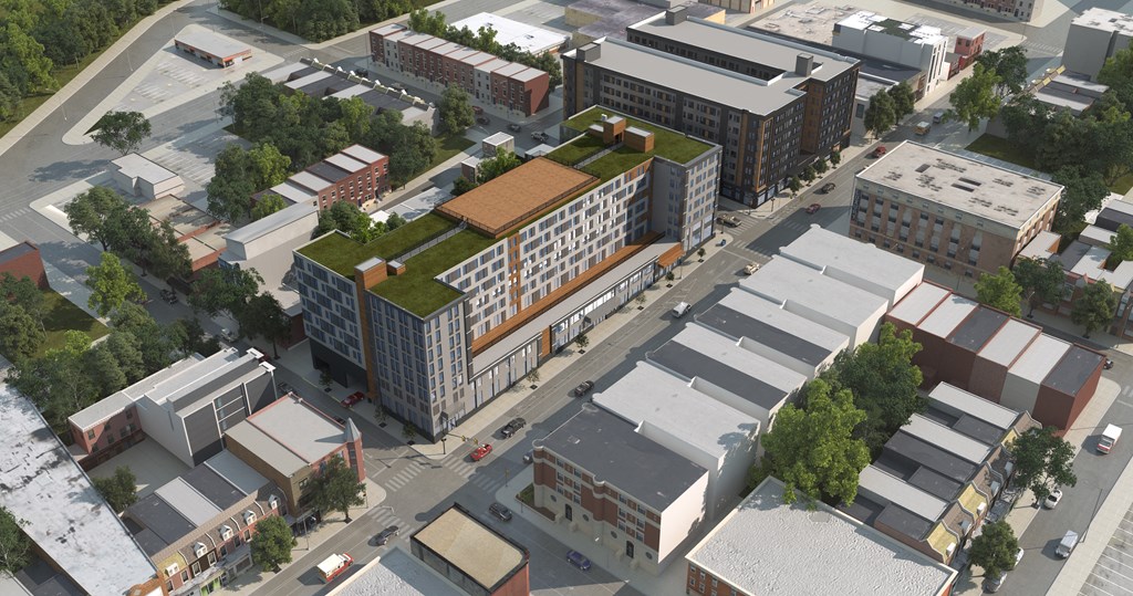 An aerial rendering of the LVL West building on the corner of 43rd and Chestnut Street, showing a modern gray exterior, orange detailing, and a green roof deck.