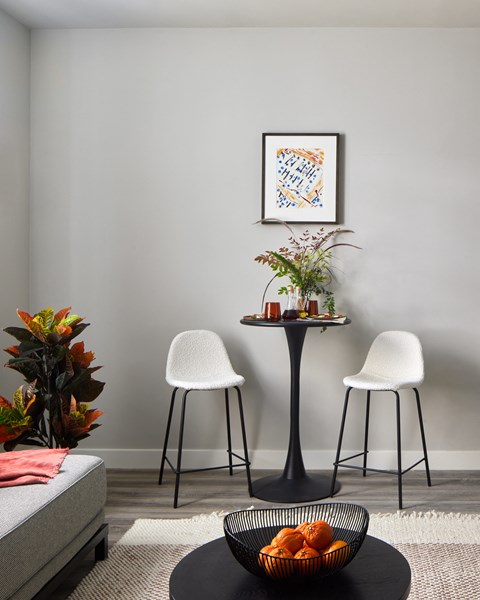 A snapshot of the living area in LVL West 1-Bedroom floorplan, featuring a bistro set with two chairs and a table.
