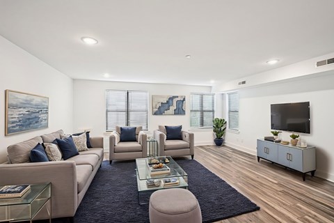 A living room with a sofa, armchairs, a coffee table, and a television.