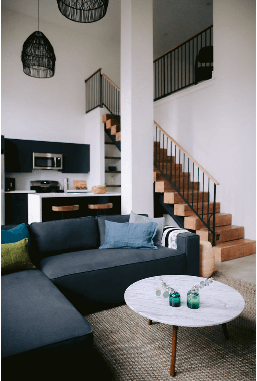 a living room with a blue couch and a white table
