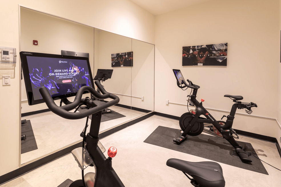 a gym with exercise equipment and a tv in a room