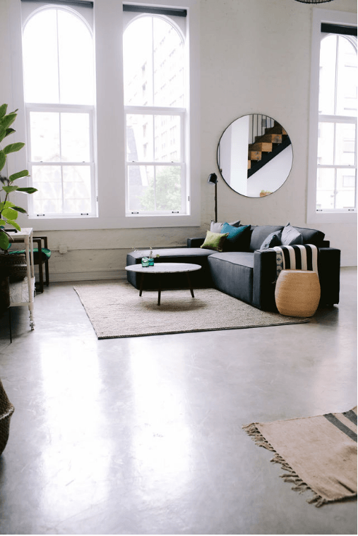 a living room with a couch and a table and a mirror