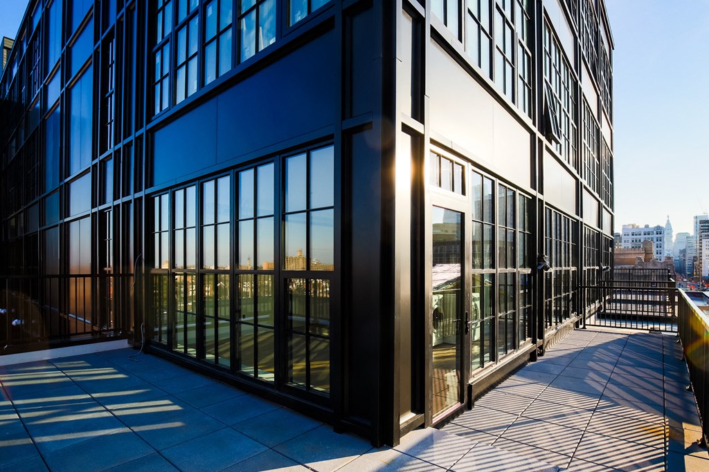 the corner of an office building with glass windows and a balcony