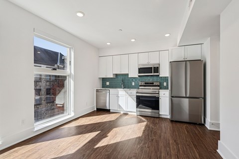 A kitchen with white cabinets and stainless steel appliances.