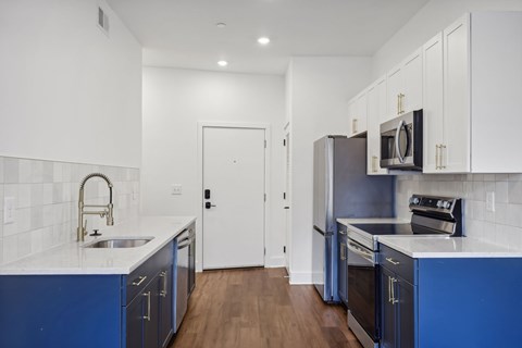 A kitchen with blue cabinets and white countertops.