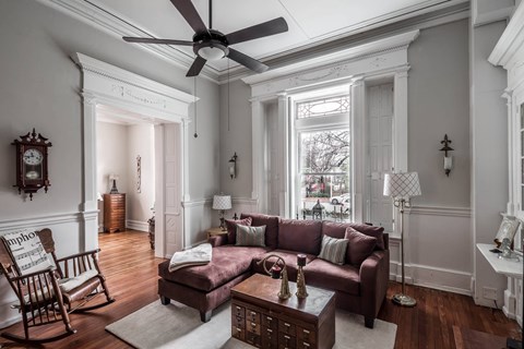 A living room with a brown couch and a wooden rocking chair.