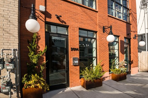 A red brick building with a black door and windows.