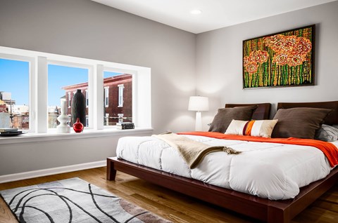 A bedroom with a large bed and a painting on the wall.