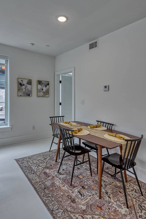A dining room with a table set for two.