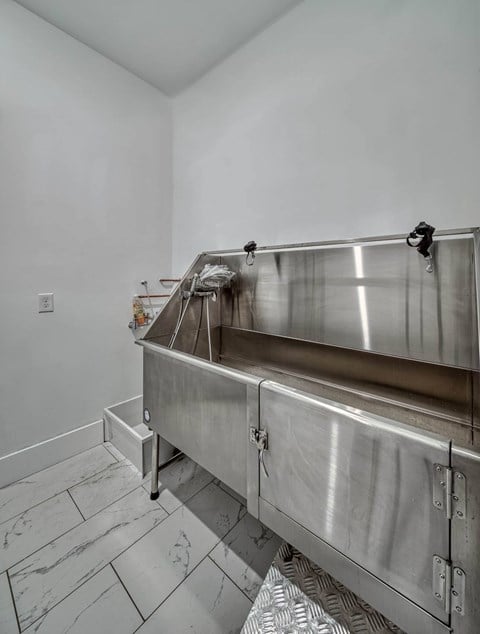 A stainless steel sink in a white room.