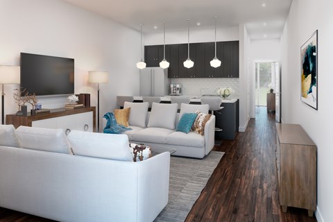 A modern living room with white furniture and a flat screen TV.