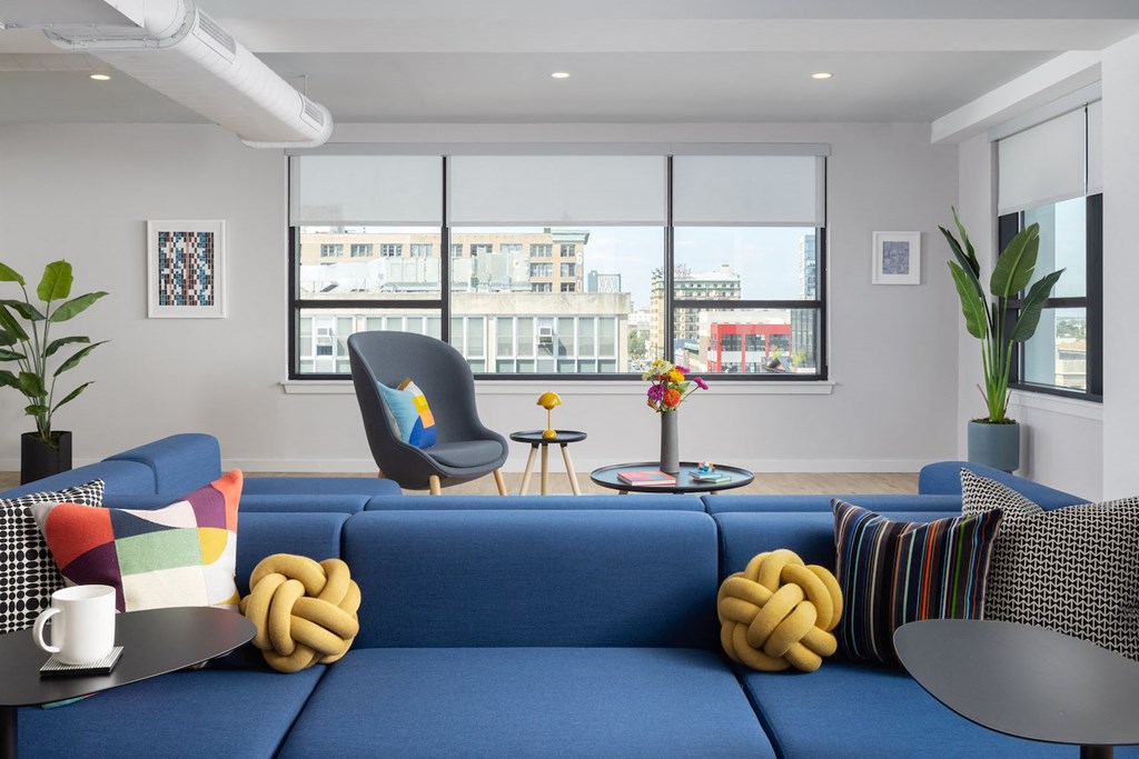 a living room with a blue couch and a table with a chair