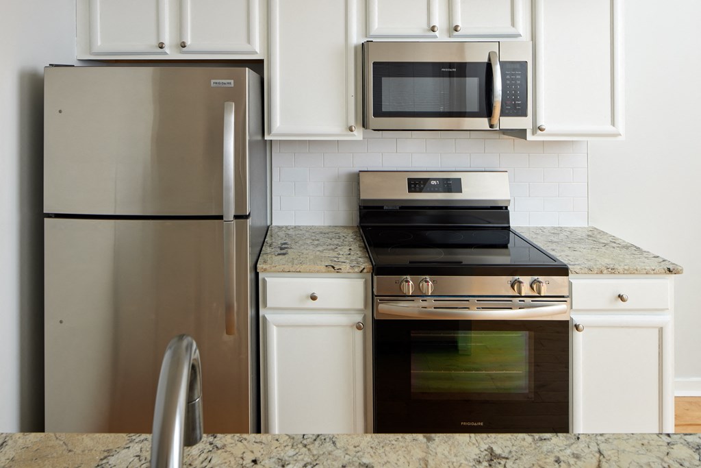 a kitchen with stainless steel appliances and white cabinets