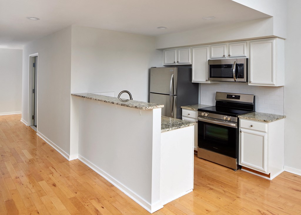 a kitchen with white cabinets and stainless steel appliances
