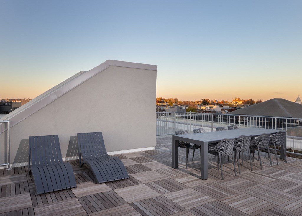 a patio with a table and chairs on top of a roof