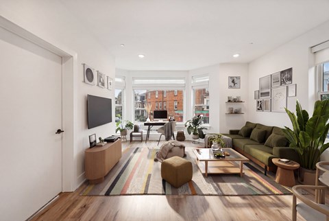 A living room with a green couch and a wooden floor.