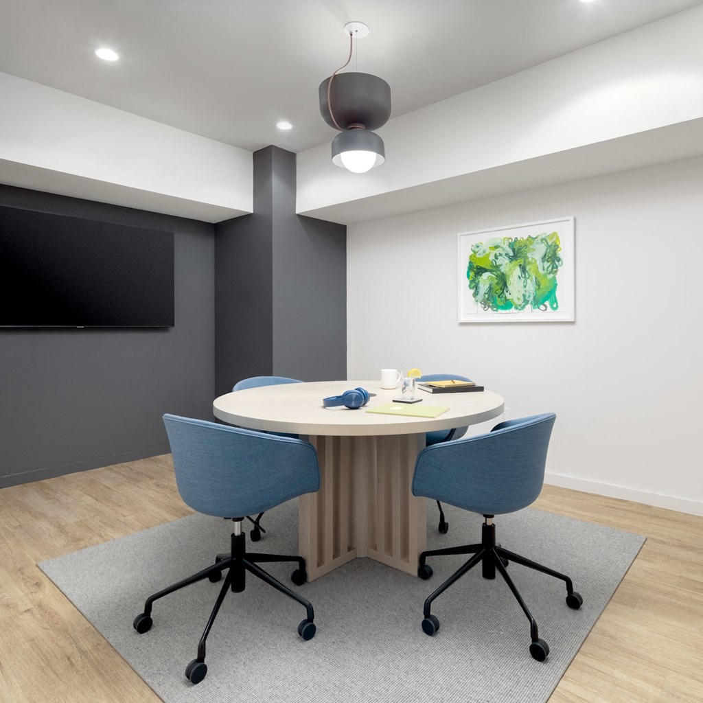 a conference room with a table and chairs and a tv