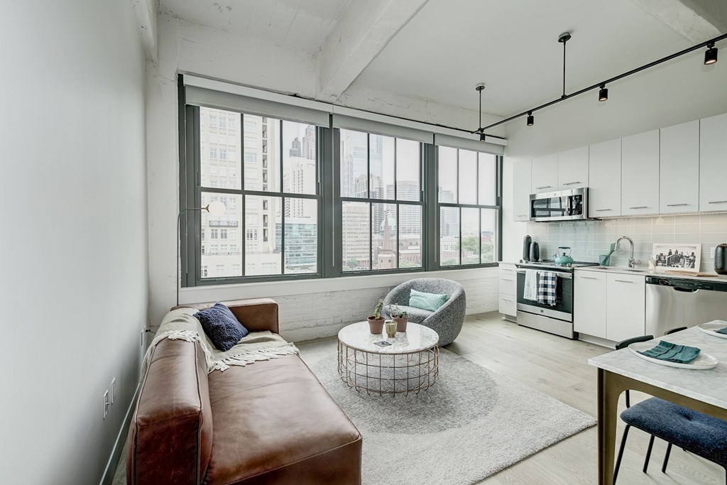 A modern living room with a brown leather couch and a large window.at 1600 Callowhill, Philadelphia, 19130