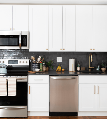 a white kitchen with stainless steel appliances and white cabinets