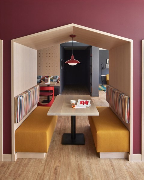 a dining room with yellow benches and a table