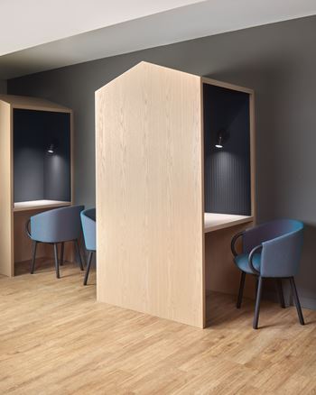 a meeting room with blue chairs and a tall wooden partition