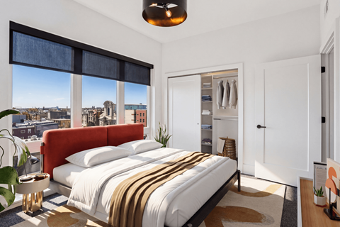 A bedroom with a large bed and a view of the city.