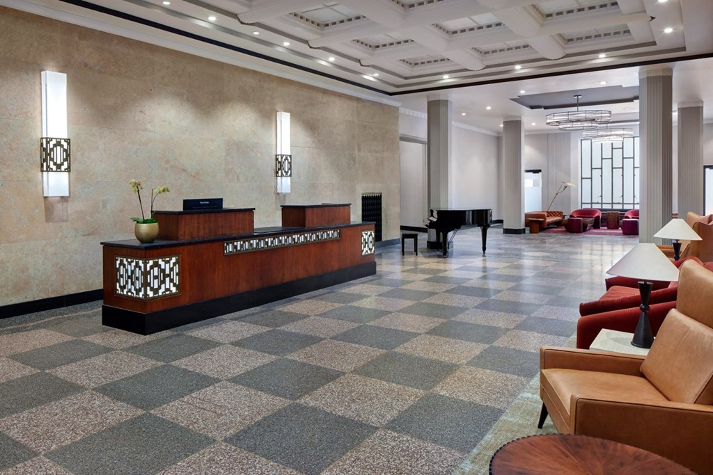 A reception area with a checkered floor and a brown sofa.