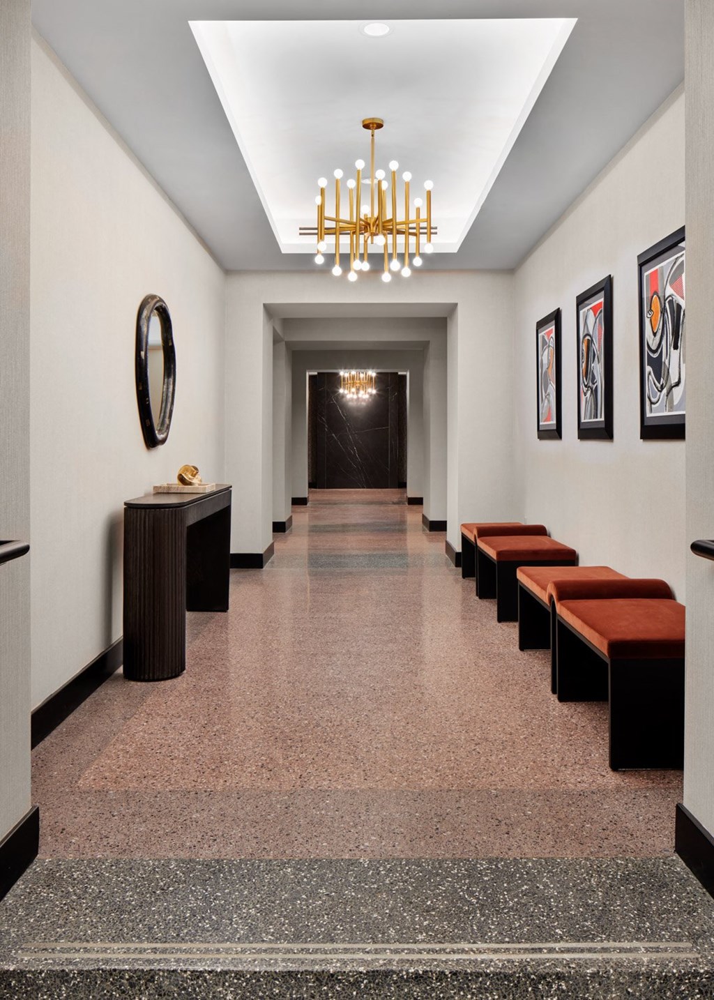 A hallway with a row of benches and pictures on the wall.