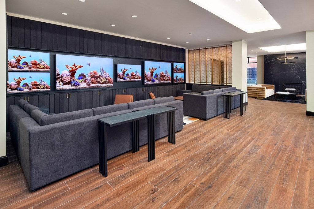 A modern living room with a grey sofa and a glass coffee table.