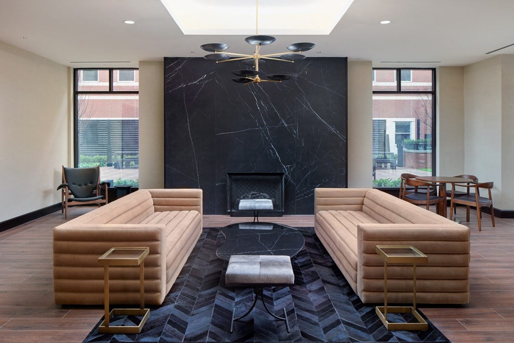 A living room with a fireplace and a black marble mantle.