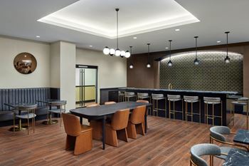 A modern dining room with a dark wood table and chairs.