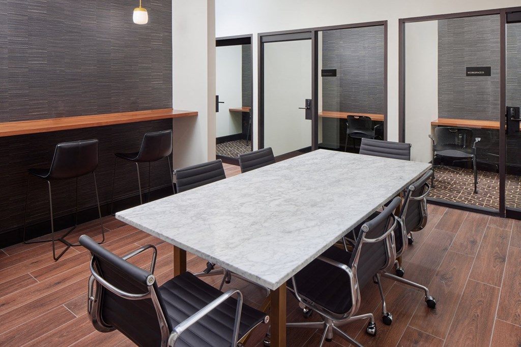 A conference room with a long table and chairs.
