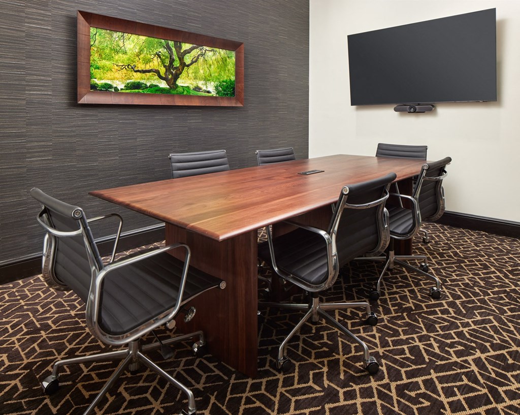 A conference room with a large table and chairs.