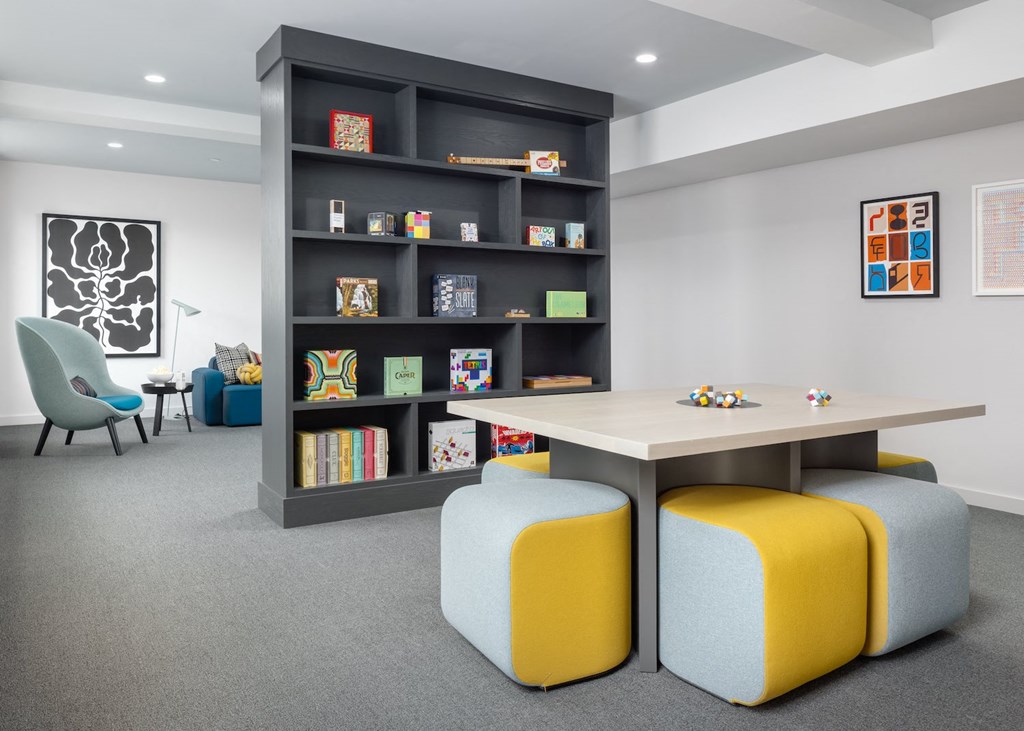 a room with a table and chairs and a bookshelf