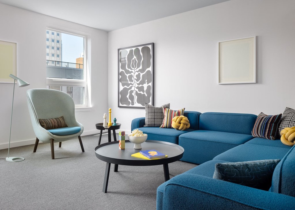 a living room with blue couches and chairs and a table