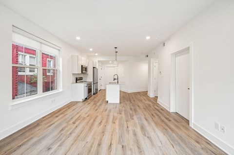 A spacious room with wooden floors and white walls.