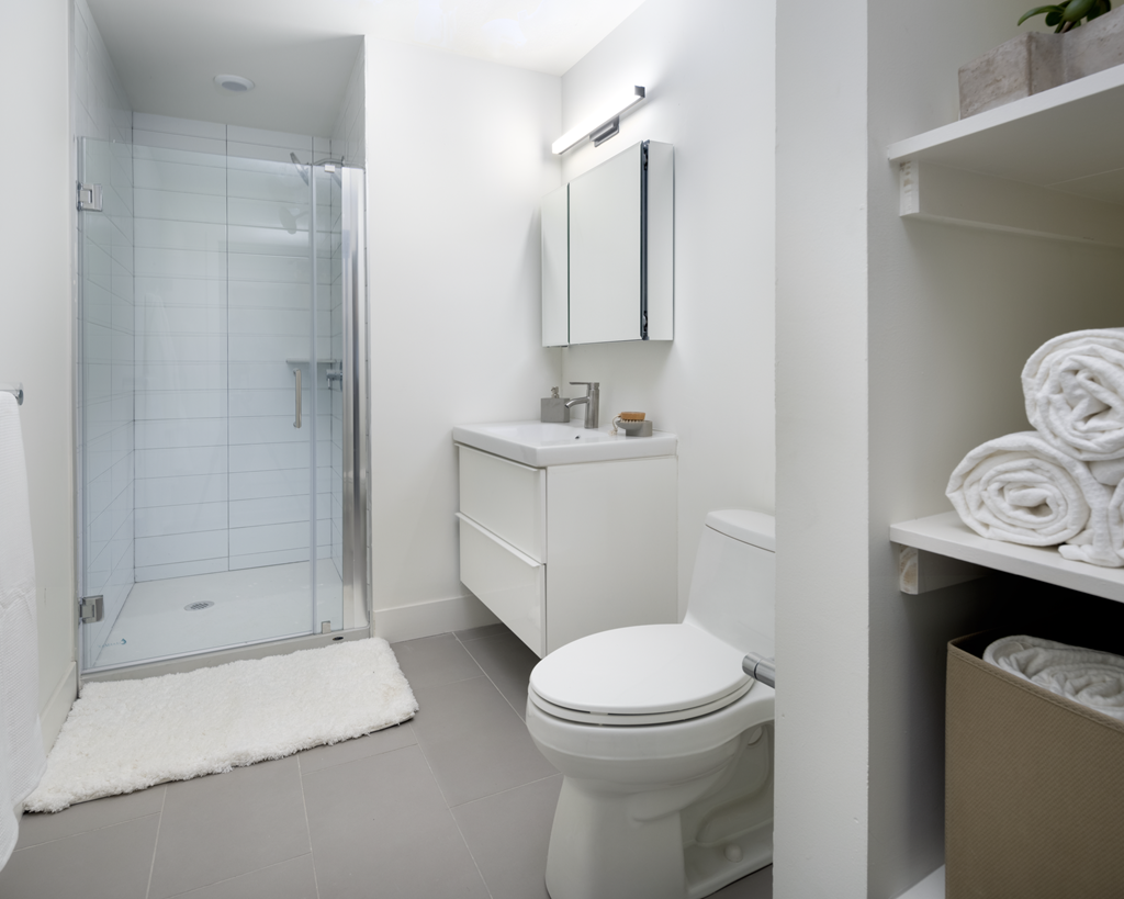 a white bathroom with a shower and a toilet
