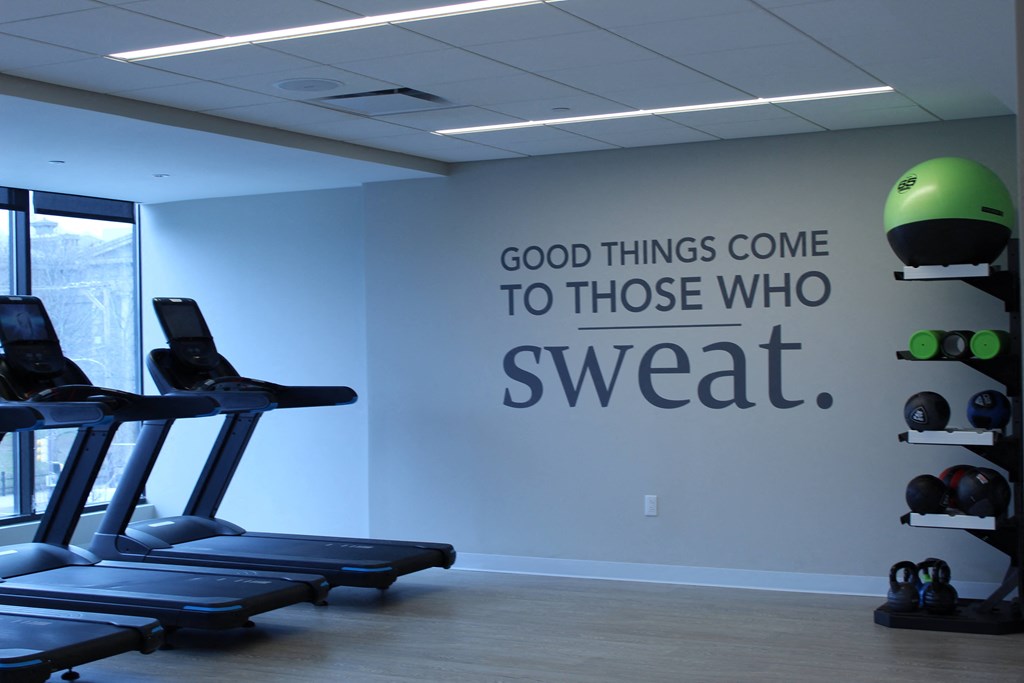 a gym wall with a quote of good things come to those who sweat