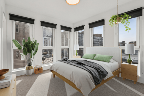A bedroom with a large bed and a view of the city.