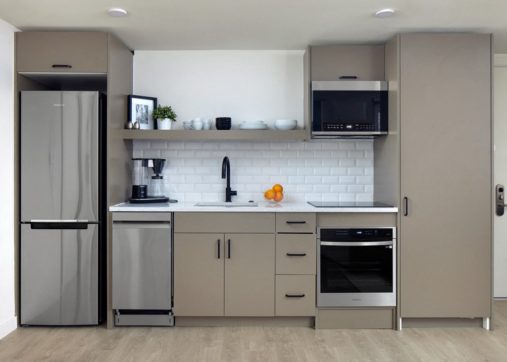 a modern kitchen with stainless steel appliances and white cabinets