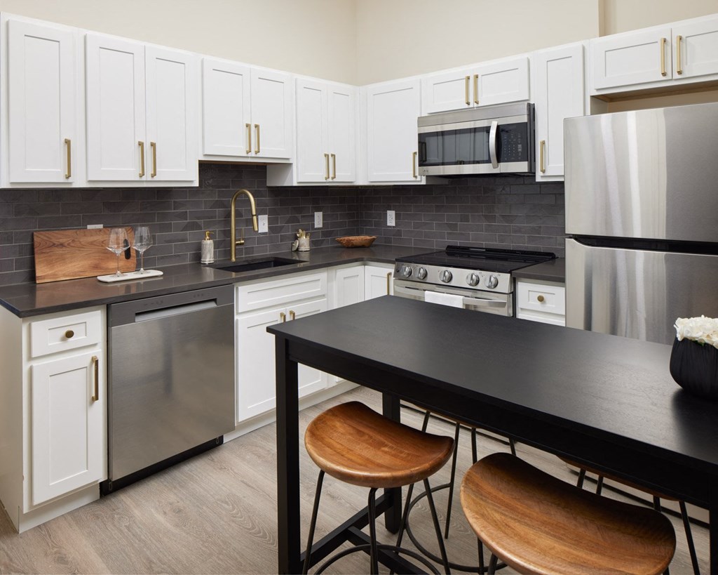 a kitchen with stainless steel appliances and a black counter top