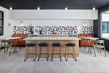 A modern bar area with a white counter and black stools. at The Weaver, Philadelphia, PA, 19125