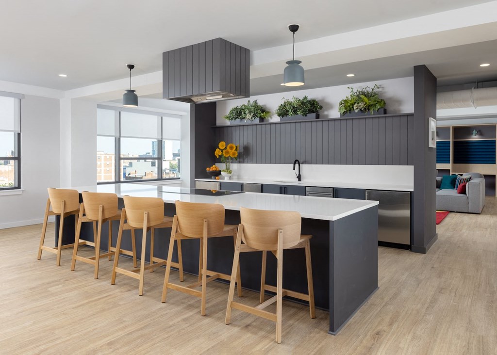 a kitchen with a large island and chairs in front of it