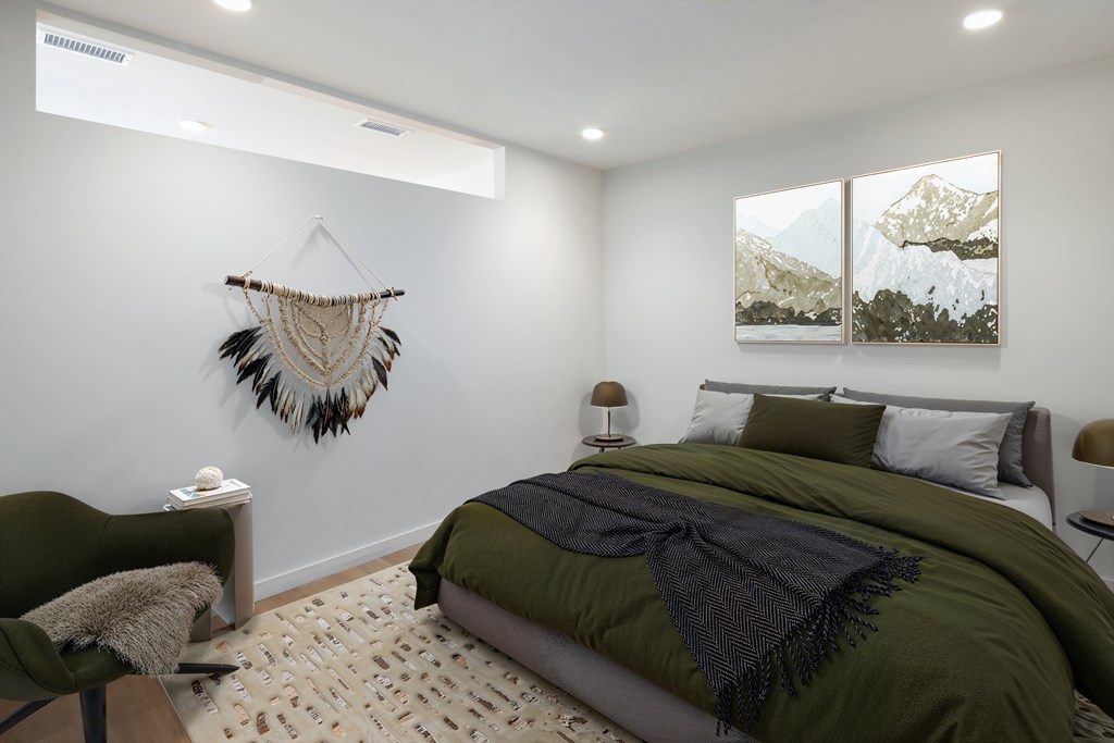 A bedroom with a green bed and a wall hanging.