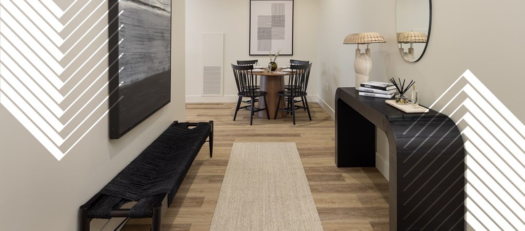 A black and white striped bench sits in a room with a table and chairs.