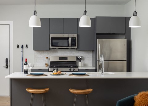 a kitchen with black cabinets and a white counter top