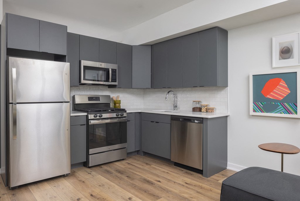 a kitchen with stainless steel appliances and gray cabinets
